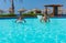 Smiling young couple doing aqua fitness in swimming pool