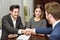 Smiling young couple shaking hands with an insurance agent