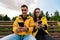 Smiling young couple in yellow jackets sitting on a bench in the autumn Park using phones, smartphones. Millennials, inseparable