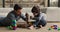 Smiling young daddy helping small son fixing car.