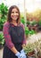 Smiling young employee in a flower nursery