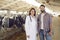 Smiling young farmer and livestock veterinarian standing in cow barn after cattle checkup