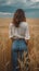 smiling young female farmer cowgirl standing in wheat cereal field. copy space