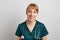 Smiling young female nursing assistant with phonendoscope in green uniform. Surgeon emergency