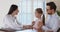 Smiling young female pediatrician listening heartbeat of small cute patient.