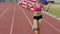 Smiling young female running on stadium with flag of USA, success in sport