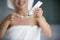 Smiling young female standing at bathroom preparing to clean teeth