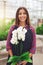 Smiling young florist holding an orchid