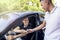 A smiling young girl receives the keys to a new car from the hands of a salesman car dealer car rental or purchase sale. bright