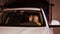 Smiling young girl sitting down in car on driver seat