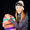 Smiling young girl in ski clothes with snowboard on black background in studio