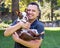 Smiling young Hispanic man hugging a puppy