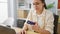 Smiling young hispanic woman, a beautiful business worker, confidently navigating online finance using her credit card and laptop