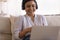 Smiling young indian businesswoman negotiating with customer using laptop headset