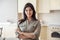 Smiling young indian woman looking at camera at home in kitchen, headshot.