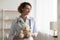 Smiling young kind female pediatrician holding teddy bear in hands.