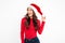 Smiling young lady in christmas hat standing isolated