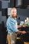 smiling young male barista doing coffee on machine in coffee