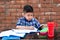 Smiling young male kid using digital smartphone watching online e-learning video to studying in classroom , Asian Indian schoolboy