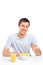 Smiling young man eating cornflakes at breakfast