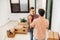 Smiling young man holds boyfriend\'s hand at the new apartment they just moved in