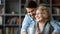 Smiling young man hugging mature mother drinking tea