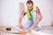 Smiling young man installing laminate flooring in new apartment