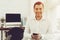 Smiling Young Man with Mobile Phone in Office.