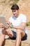 Smiling young man using tablet on the beach