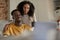 Smiling young multiethnic couple using a laptop together in their kitchen