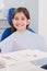 Smiling young patient sitting in dentists chair