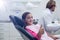 Smiling young patient sitting on dentists chair