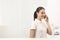 Smiling young receptionist talking on phone at checkout counter