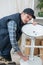 Smiling young repairman fixing chair in workshop