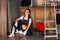 smiling young repairwoman relaxing while sitting on floor