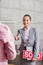 Smiling young saleswoman holding sold placard and document while greeting man in apartment