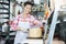 Smiling Young Saleswoman Slicing Cheese With Knife In Shop