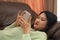 Smiling young teen girl sitting on sofa at home