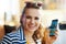 Smiling young traveller woman booking tickets on smartphone