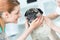 Smiling young veterinary doctor and girl stroking pug at hospital