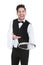 Smiling young waiter holding empty serving tray