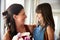 Smiling young white girl giving her mother a bunch of flowers on Motherï¿½s Day, close up