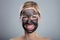 Smiling Young Woman With Activated Charcoal Face Mask