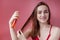 Smiling young woman applying oil mask to hair tips, haircare concept