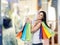 Smiling young woman with the colourful shopping bags from the fancy shops.