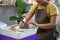 Smiling young woman creating handicraft crockery on the pottery wheel in workshop