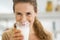 Smiling young woman drinking milk