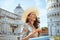 Smiling young woman in floral dress with pizza and hat