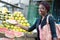 Smiling young woman grabs a slice of ripe fruit.