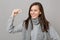 Smiling young woman in gray sweater, scarf holding medication tablet, aspirin pill isolated on grey background. Healthy